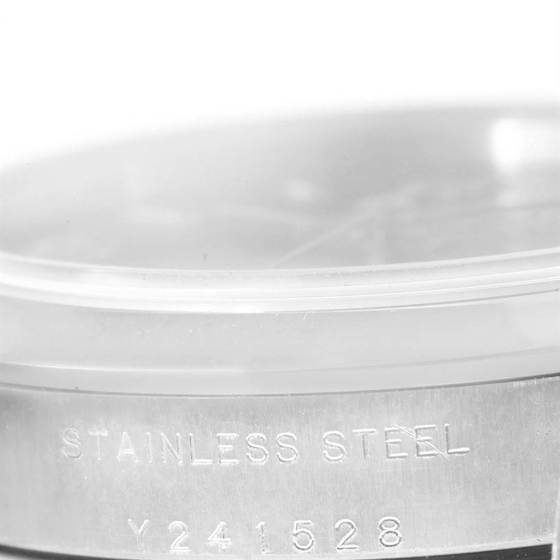 The image shows a partial close-up of the case back of a Mid-Size Rolex watch, highlighting the "STAINLESS STEEL" engraving.