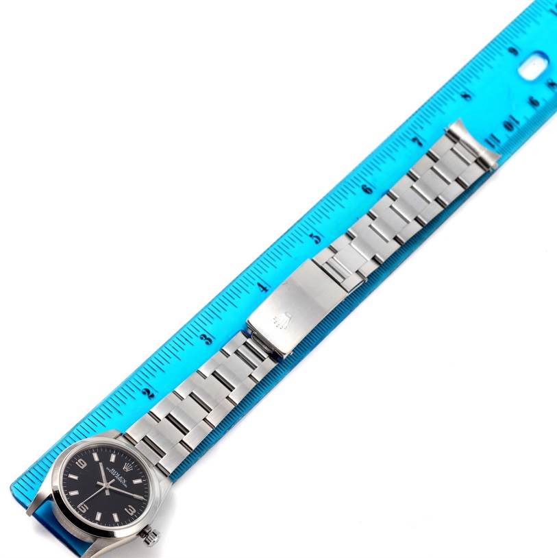 This image showcases a Rolex Mid-Size 77080 Women's Stainless Steel Black Dial 77080 Women's Stainless Steel Black Dial watch with its bracelet extended against a measuring ruler.