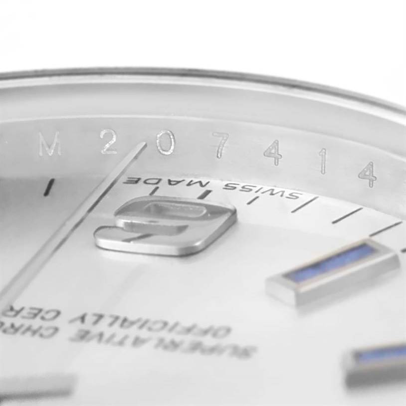 The image captures a close-up angle of the dial and bezel of a Mid-Size Rolex watch, highlighting its serial number and "Swiss Made" text.