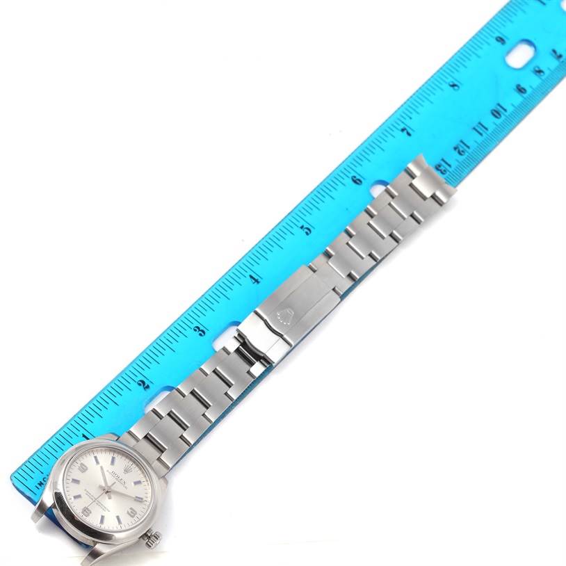 The image shows a Mid-Size Rolex watch with the dial, bracelet, and clasp laid out next to a blue ruler.