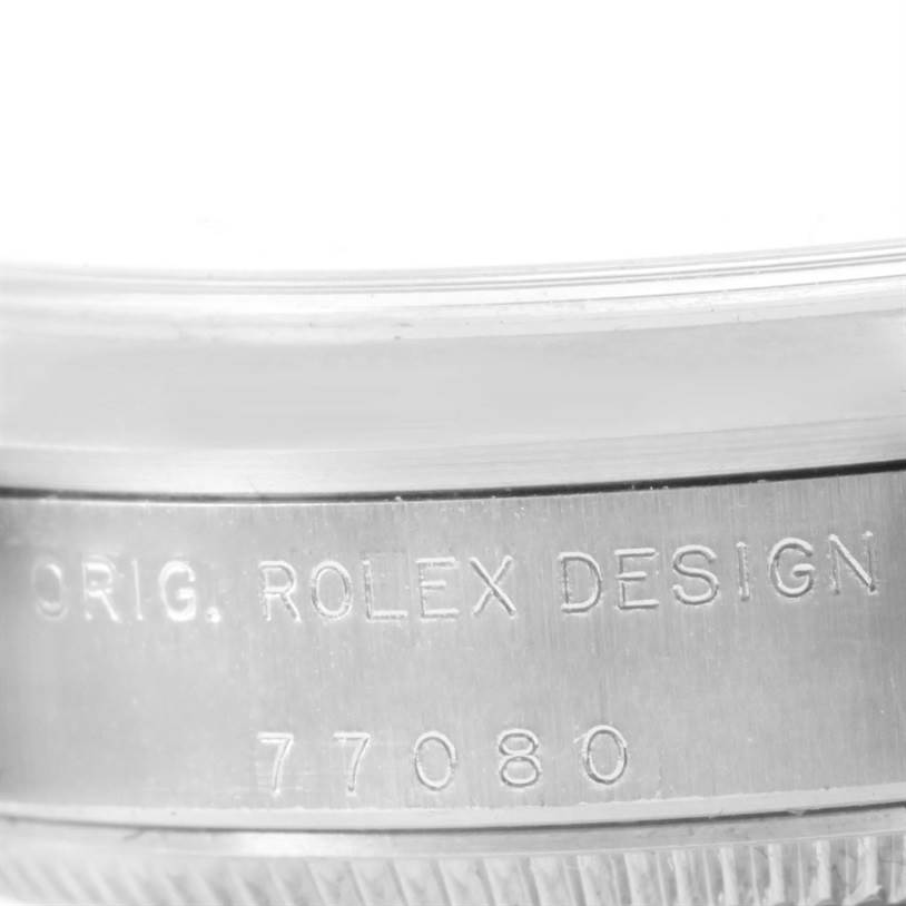 The image shows a close-up of the side of a Rolex Mid-Size 77080 Women's Stainless Steel Pink Dial 77080 Women's Stainless Steel Pink Dial watch, highlighting the model number "77080" and the "ORIG. ROLEX DESIGN" engraving.