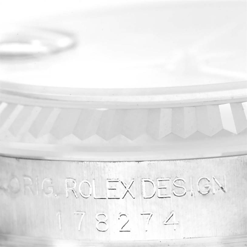 This is a close-up angle of a Mid-Size Rolex watch displaying part of the bezel and the engraved case side.