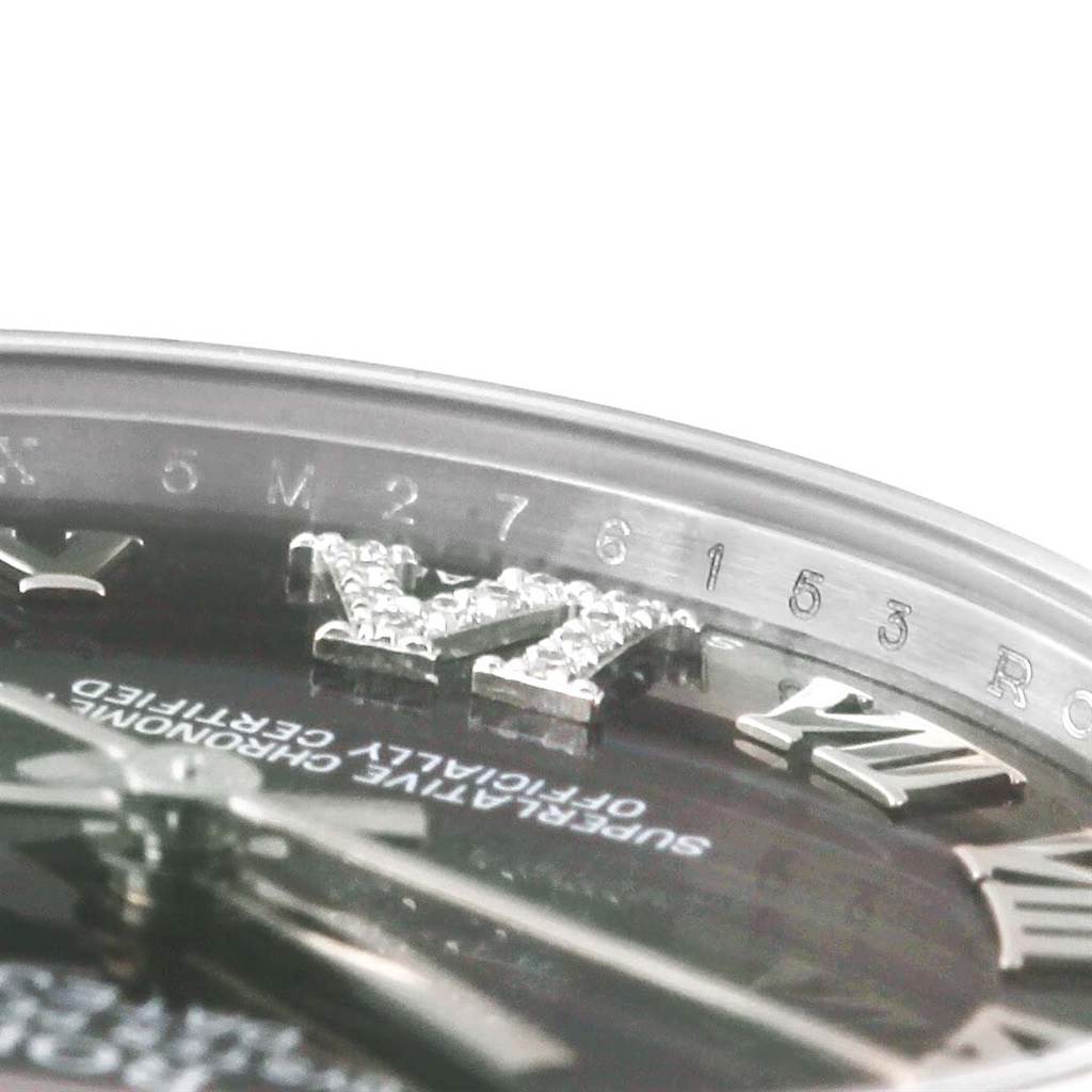 This close-up image of a Rolex Mid-Size 178344 Women's Stainless Steel Purple Dial 178344 Women's Stainless Steel Purple Dial model watch shows the bezel, part of the dial, Roman numeral markers, and the edge of the crystal.