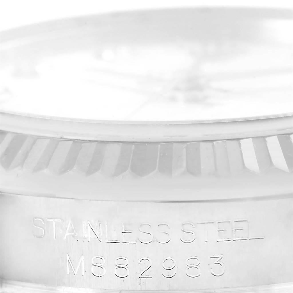 The image shows a close-up of the stainless steel casing and fluted bezel of a Mid-Size Rolex watch.