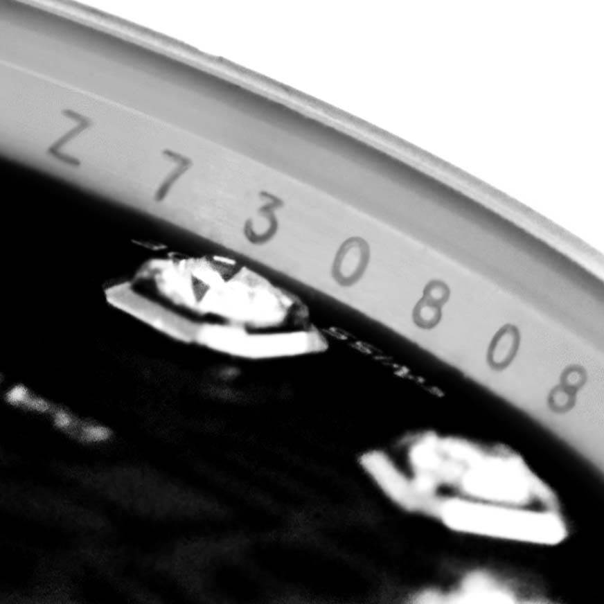 This close-up image shows the partial serial number on the edge and diamond markers of a Mid-Size Rolex watch's dial.