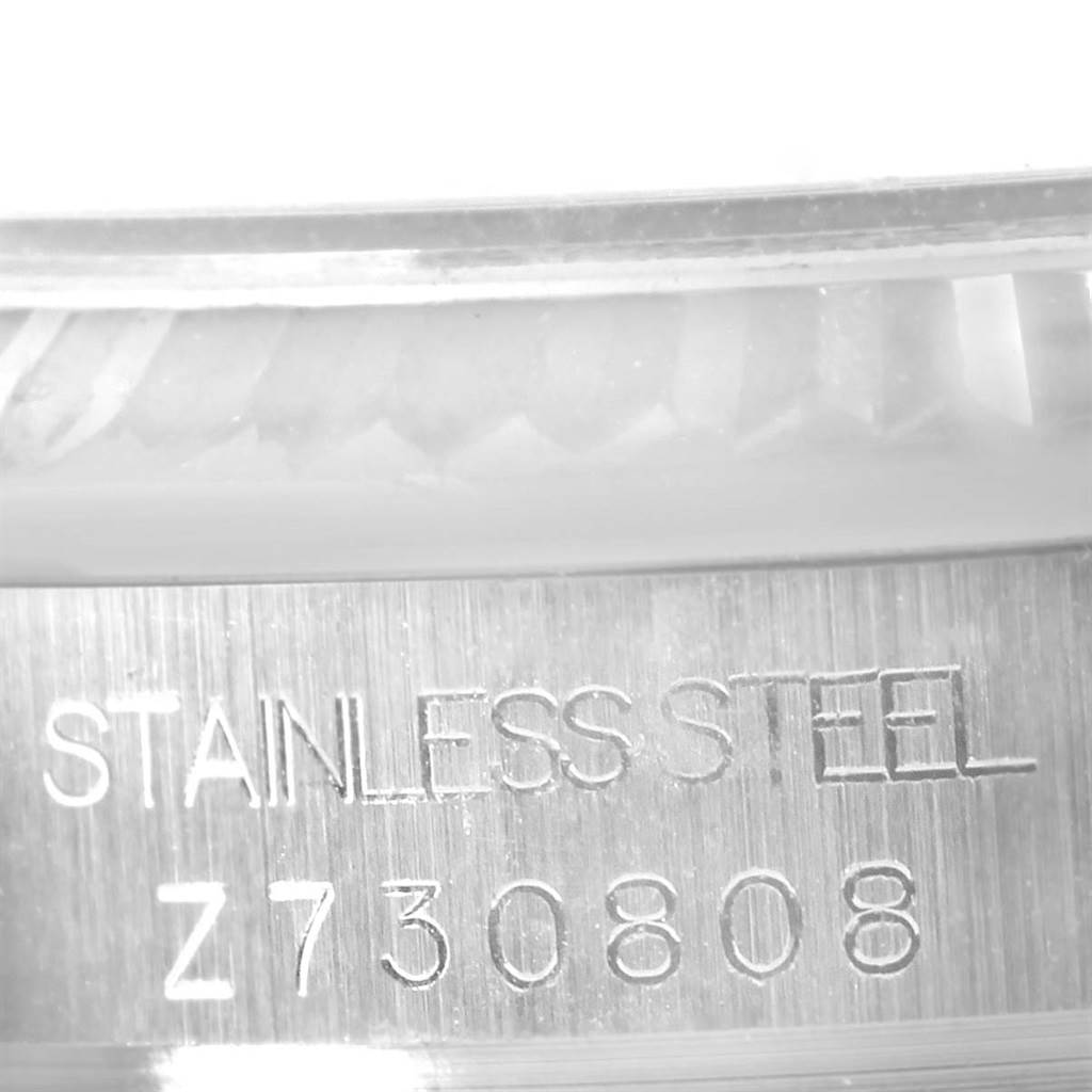 This close-up shot of a Rolex Mid-Size 178274 Women's Stainless Steel Black Dial 178274 Women's Stainless Steel Black Dial watch shows the engraved stainless steel casing and serial number Z730808.