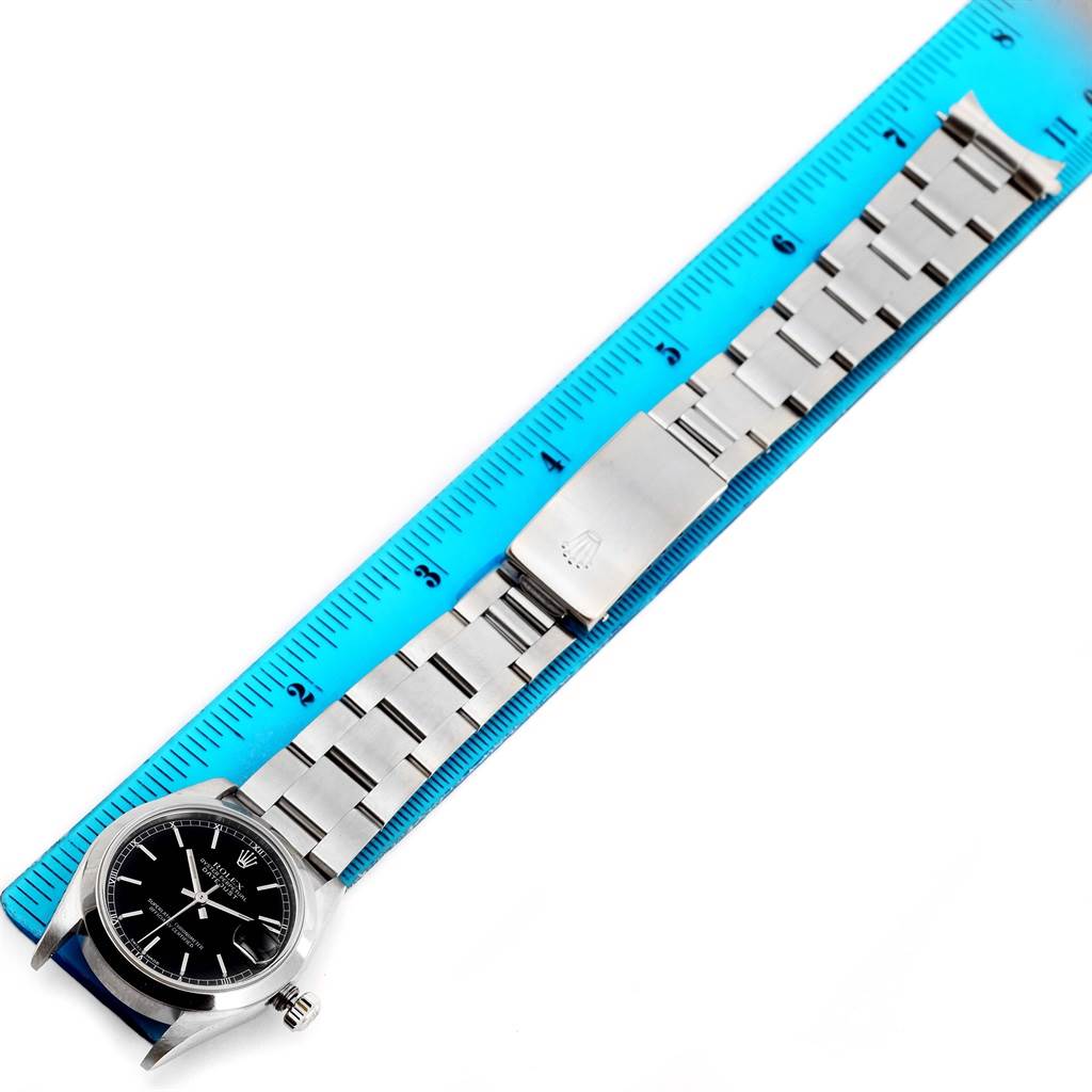 The image shows a Rolex Mid-Size 78240 Women's Stainless Steel Black Dial 78240 Women's Stainless Steel Black Dial watch laid flat beside a ruler, displaying the watch face, bracelet, and clasp.