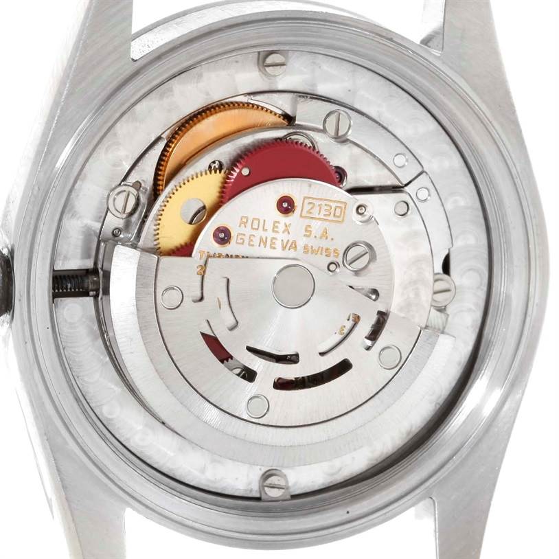 The image shows the exposed back of a Mid-Size Rolex watch, revealing its internal mechanical components.