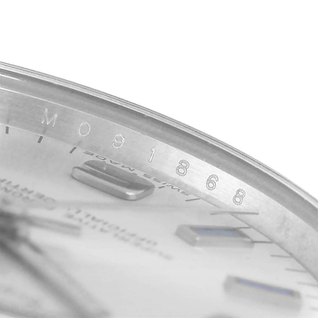 This close-up image of a Rolex Mid-Size 177200 Women's Stainless Steel Silver Dial 177200 Women's Stainless Steel Silver Dial model watch shows the serial number engraved on the inner bezel and part of the dial.