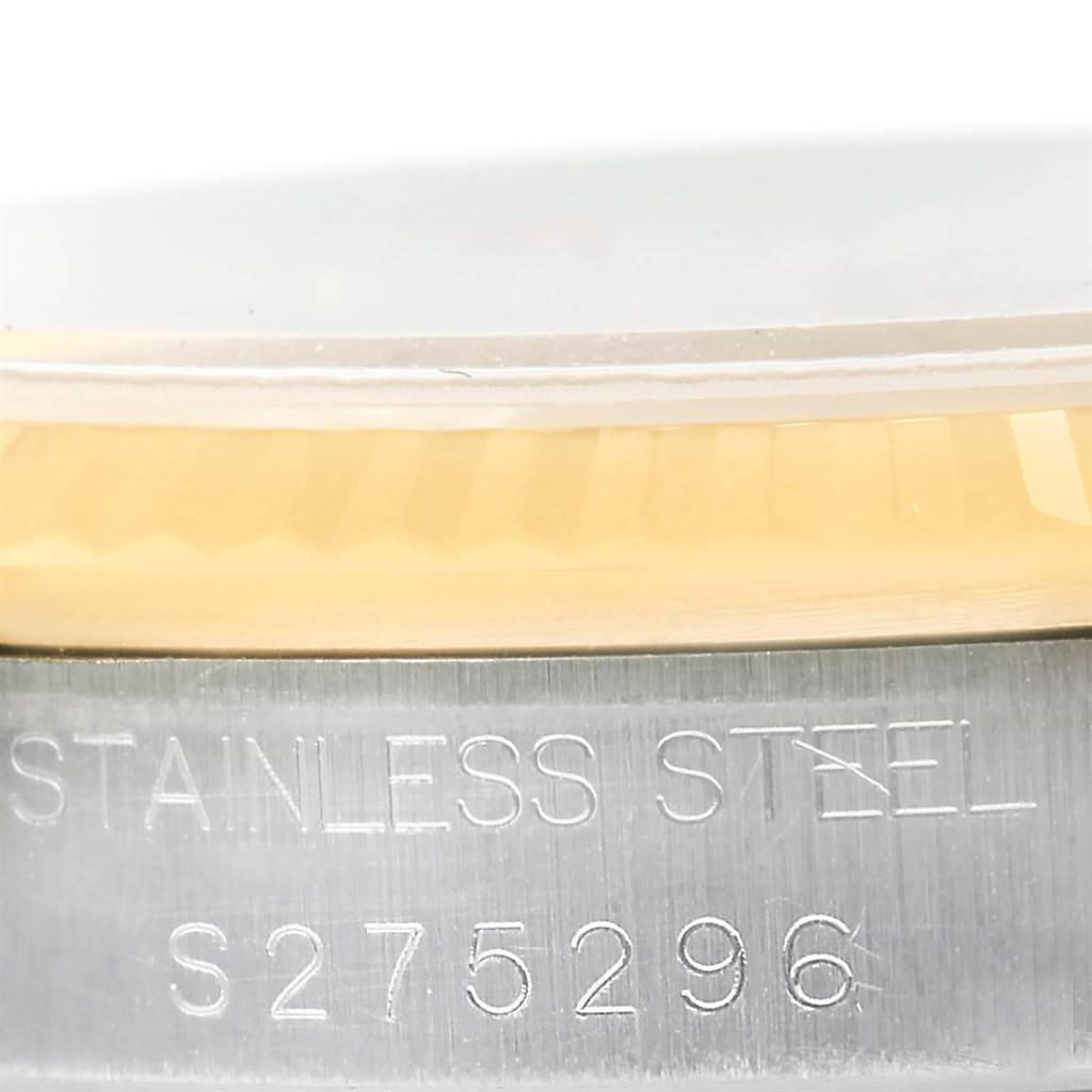 This close-up image of a Mid-Size Rolex watch shows part of the bezel and the serial number engraving on the stainless steel case.