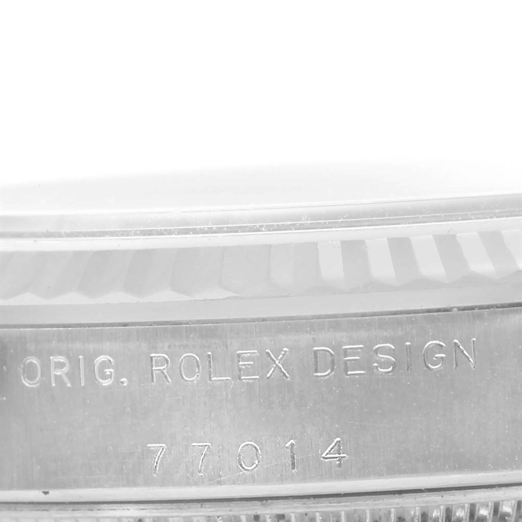 The image shows a close-up view of the bezel and case side of the Rolex Mid-Size 77014 Women's Stainless Steel Silver Dial 77014 Women's Stainless Steel Silver Dial watch, focusing on the serial number engraving.