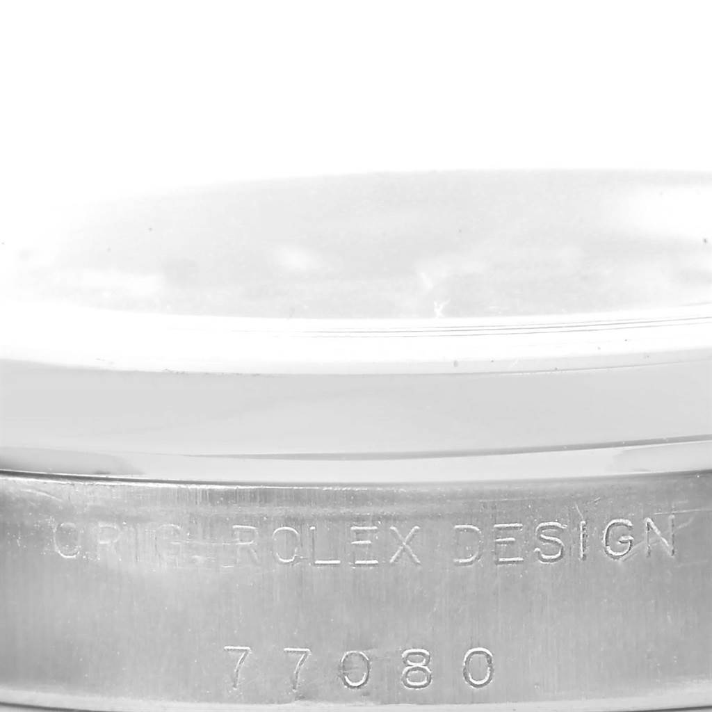 The image shows a close-up of the side of a Rolex Mid-Size 77080 Women's Stainless Steel Blue Dial 77080 Women's Stainless Steel Blue Dial model, highlighting the engraved "ORIG ROLEX DESIGN" and model number.
