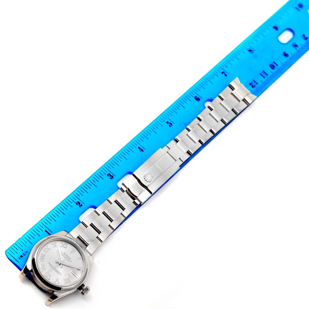 The image shows a Rolex Mid-Size 178240 Women's Stainless Steel Grey Dial 178240 Women's Stainless Steel Grey Dial watch laying flat with its bracelet extended along a blue ruler for scale.