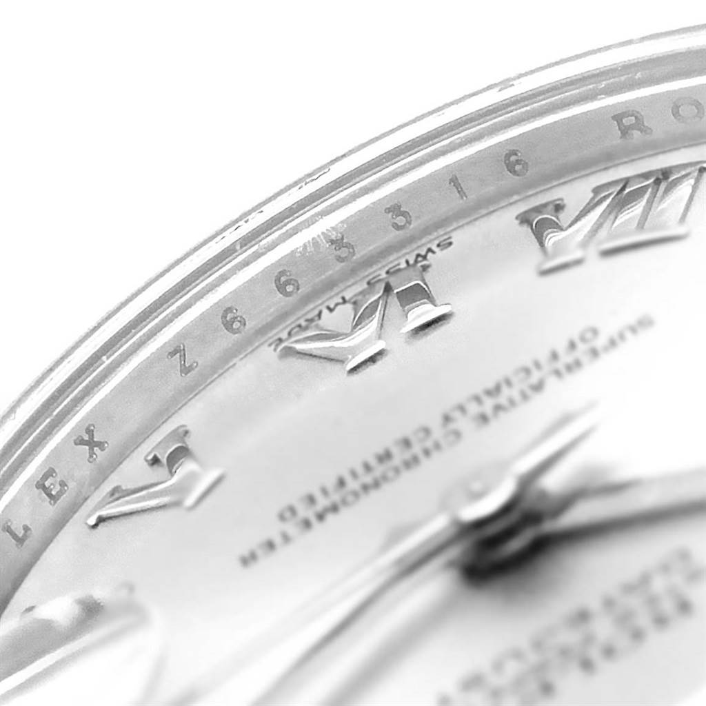 This close-up image shows part of the dial and bezel of the Mid-Size Rolex watch, including Roman numerals and the brand name.