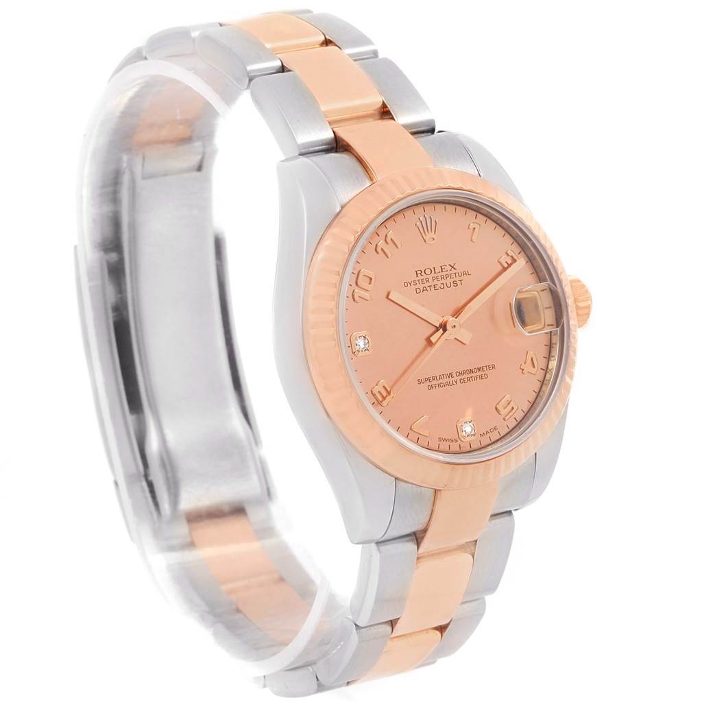 The Mid-Size Rolex watch is shown at a three-quarter angle, displaying its pink dial, fluted bezel, and mixed metal bracelet.