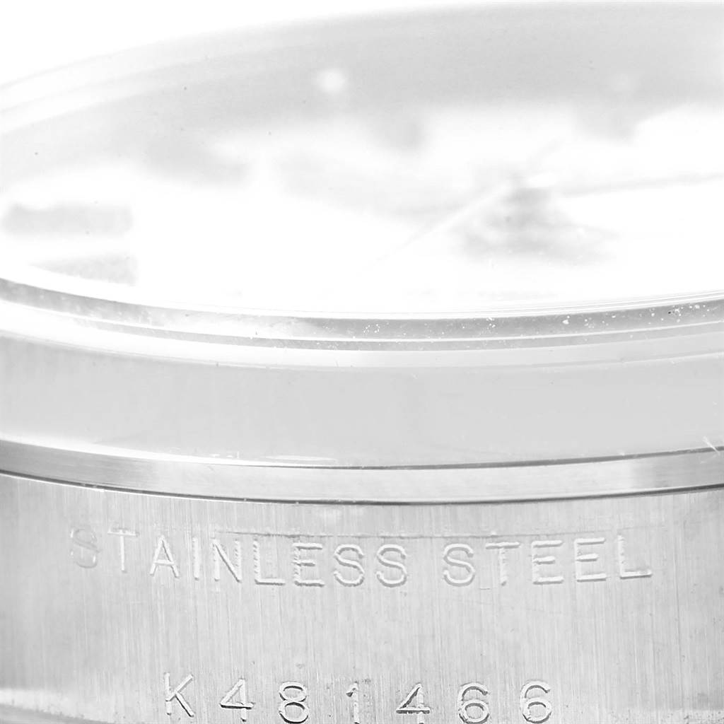 The image shows a close-up of the side of a Rolex Mid-Size 78240 Women's Stainless Steel Silver Dial 78240 Women's Stainless Steel Silver Dial watch with "STAINLESS STEEL" and the serial number engraved.