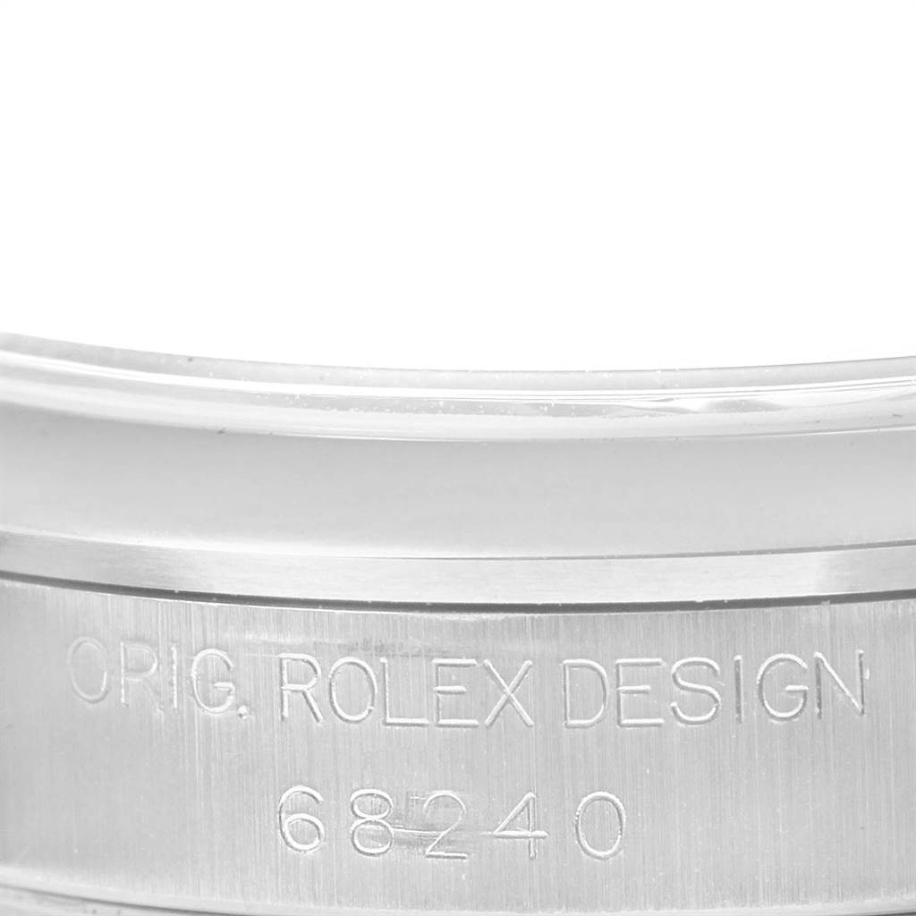 This image shows a close-up of the serial number engraving on the bezel of a Rolex Mid-Size 68240 Women's Stainless Steel Black Dial 68240 Women's Stainless Steel Black Dial model watch.