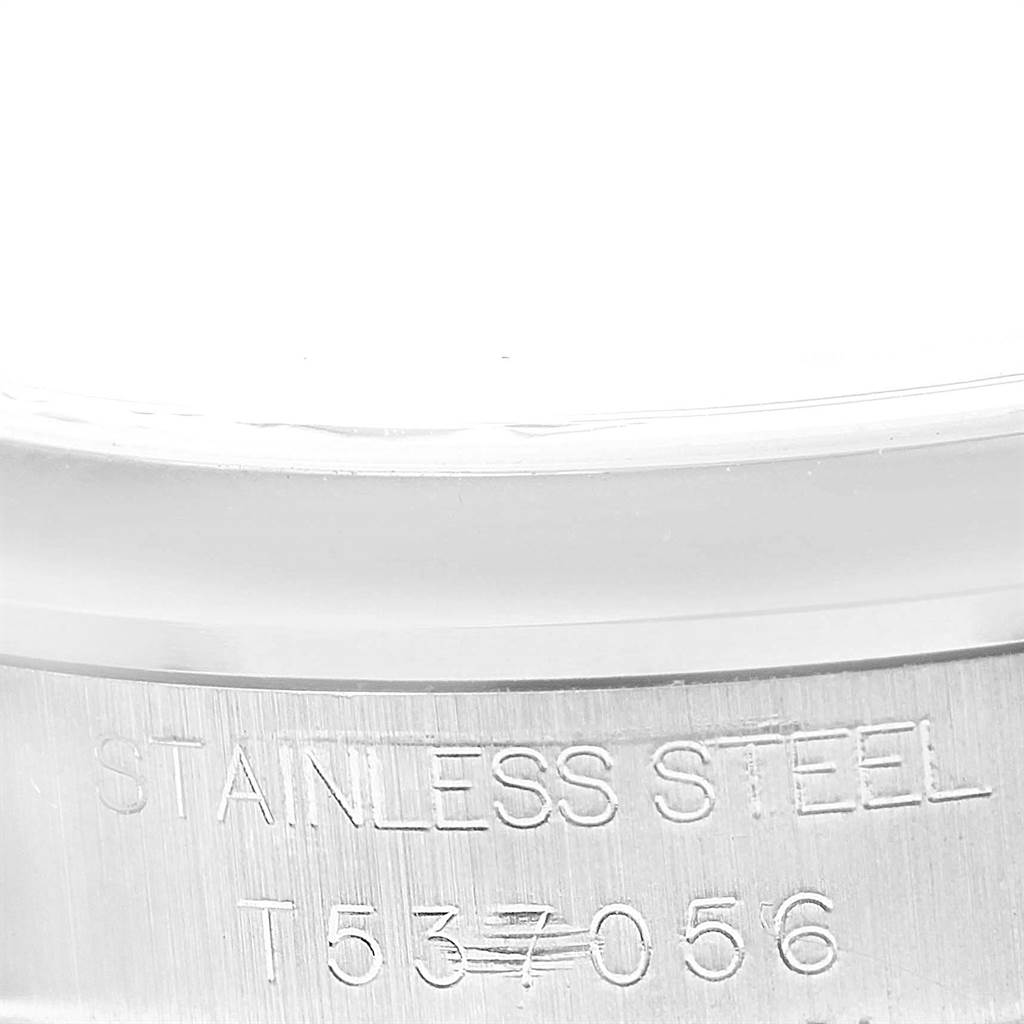 The image shows a close-up of the stainless steel case back of the Mid-Size Rolex watch, highlighting its stamped serial number.