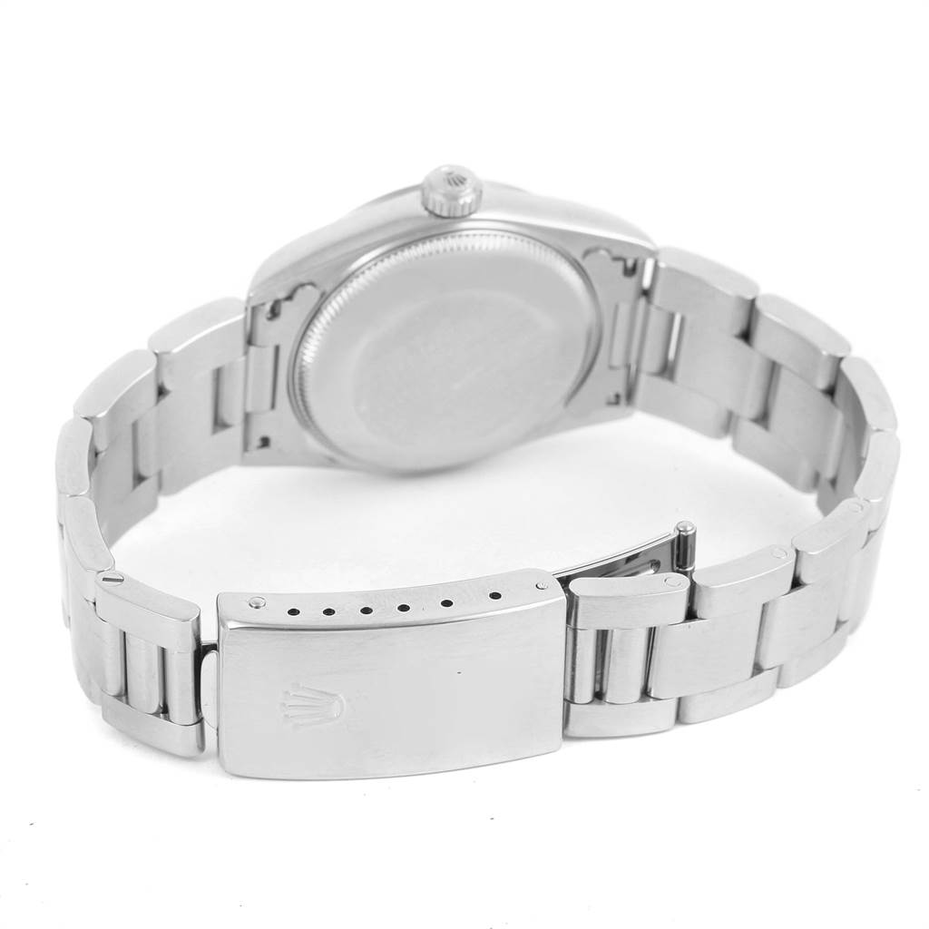 The image shows the back view of a Mid-Size Rolex watch, showcasing its case back, crown, and bracelet clasp.