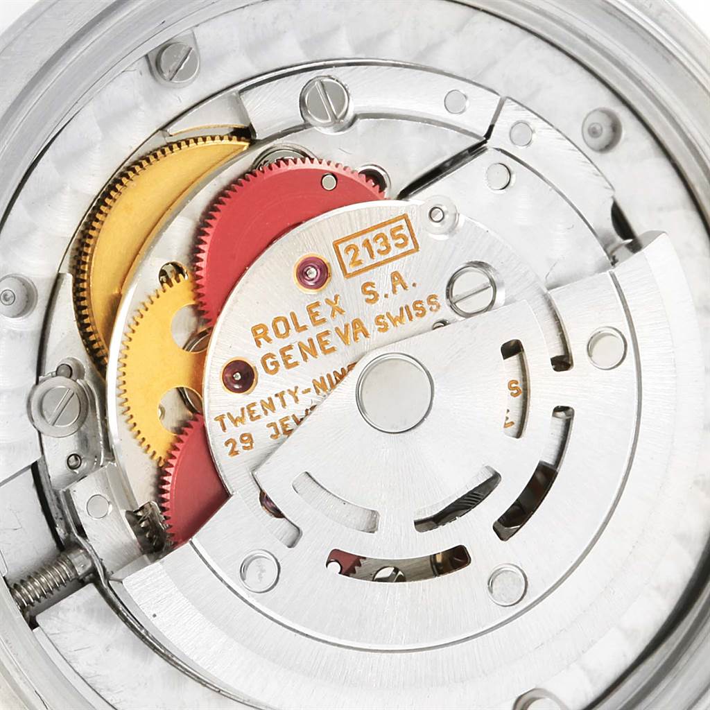 The image shows the movement mechanism of a Rolex Mid-Size 68240 Women's Stainless Steel Black Dial 68240 Women's Stainless Steel Black Dial model watch from an interior angle, revealing its gears and components.