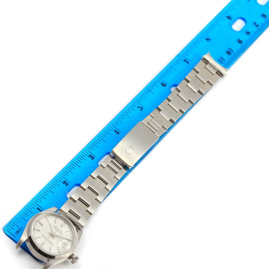 This image shows a Rolex Mid-Size 78240 Men's Stainless Steel Silver Dial 78240 Men's Stainless Steel Silver Dial watch placed alongside a blue ruler, displaying the dial, bracelet, and clasp from a top-down angle.