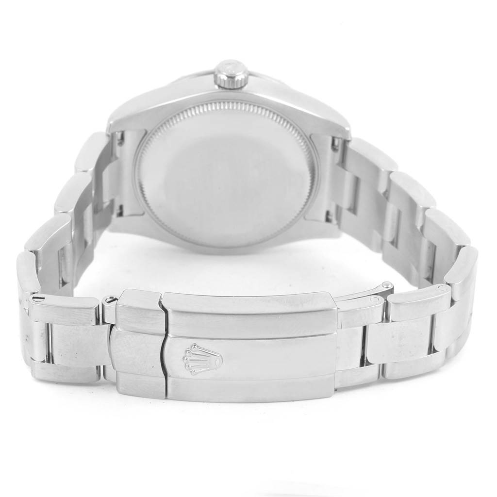 The image shows the back view of a Mid-Size Rolex watch, highlighting the case back and metal band with the clasp.