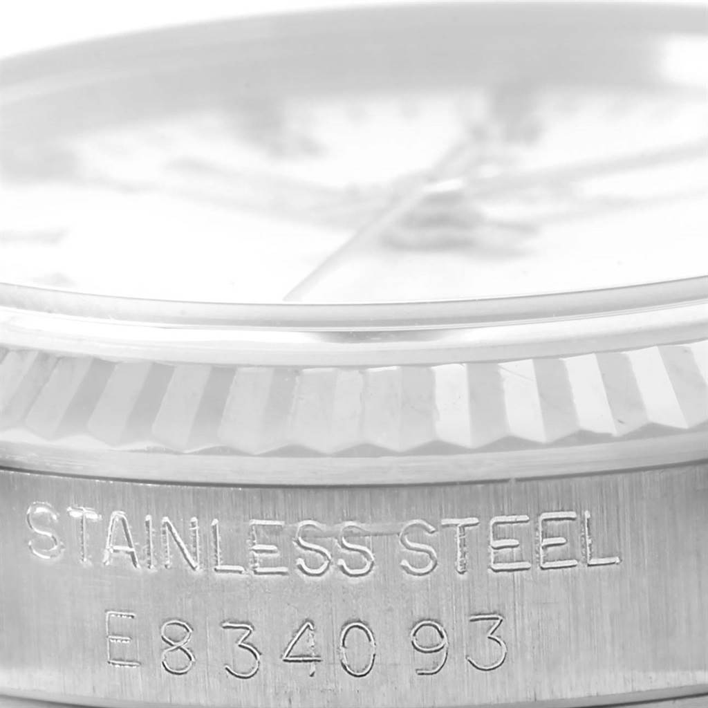 This image shows a close-up, side view of a stainless steel Rolex Mid-Size 67514 Women's Stainless Steel White Dial 67514 Women's Stainless Steel White Dial watch casing, highlighting the bezel and part of the engraved serial number.