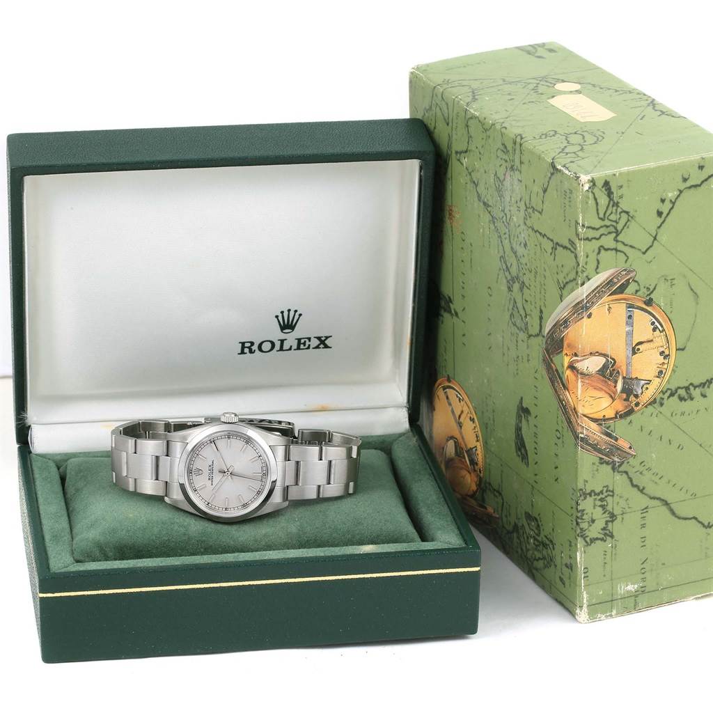 The Mid-Size Rolex watch is shown from a front angle, placed in an open case with the packaging beside it.