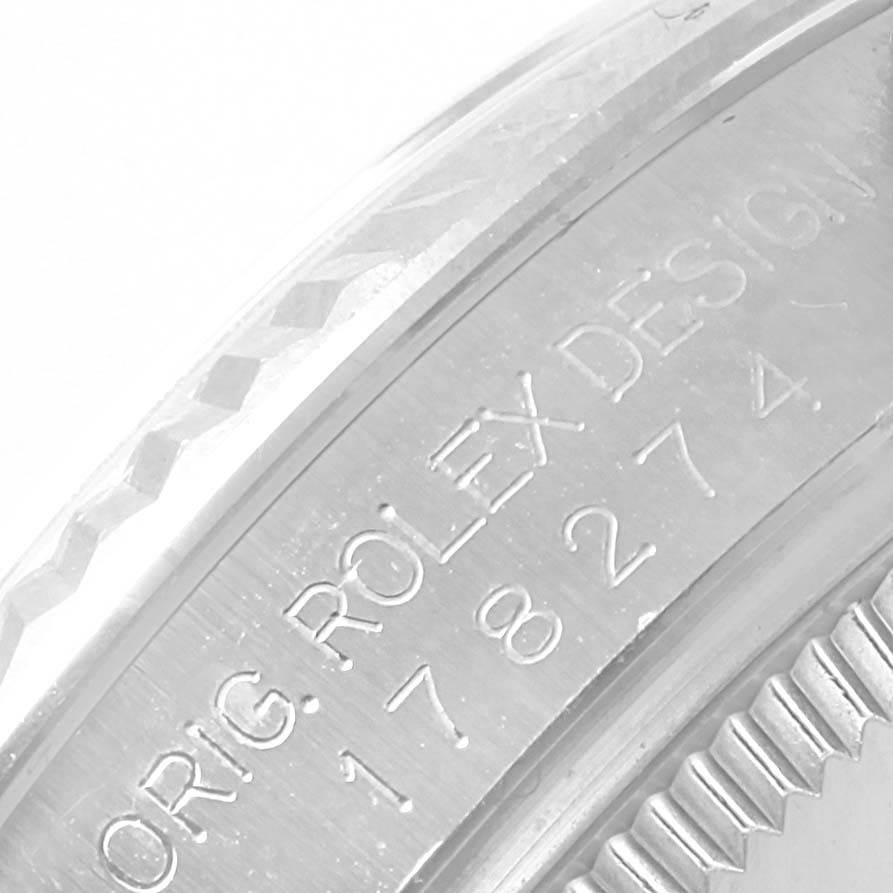 The image shows a close-up of the bezel and engraved serial number of a Mid-Size Rolex watch.