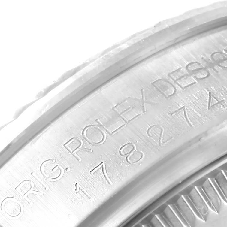 The image shows a close-up of the engraved side of a mid-size Rolex watch bezel with partial model and design text visible.