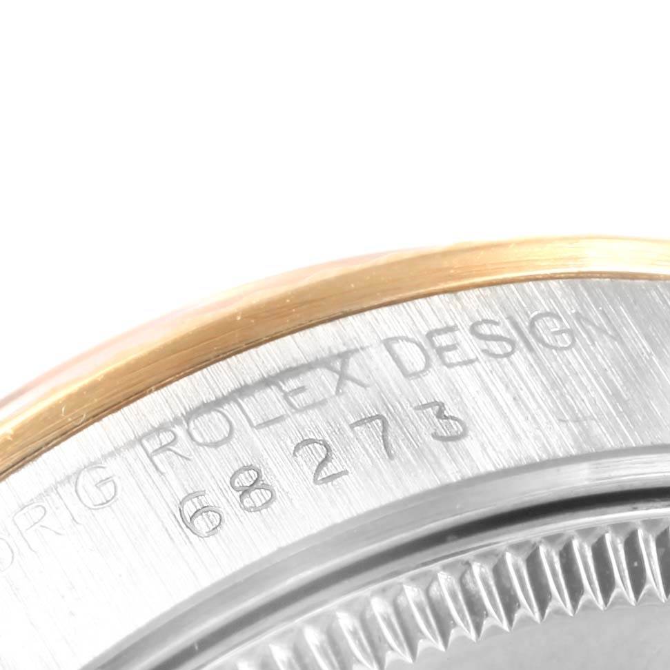 The image shows a close-up of the side and bezel of a Mid-Size Rolex watch, displaying the model engraving and part of the case.