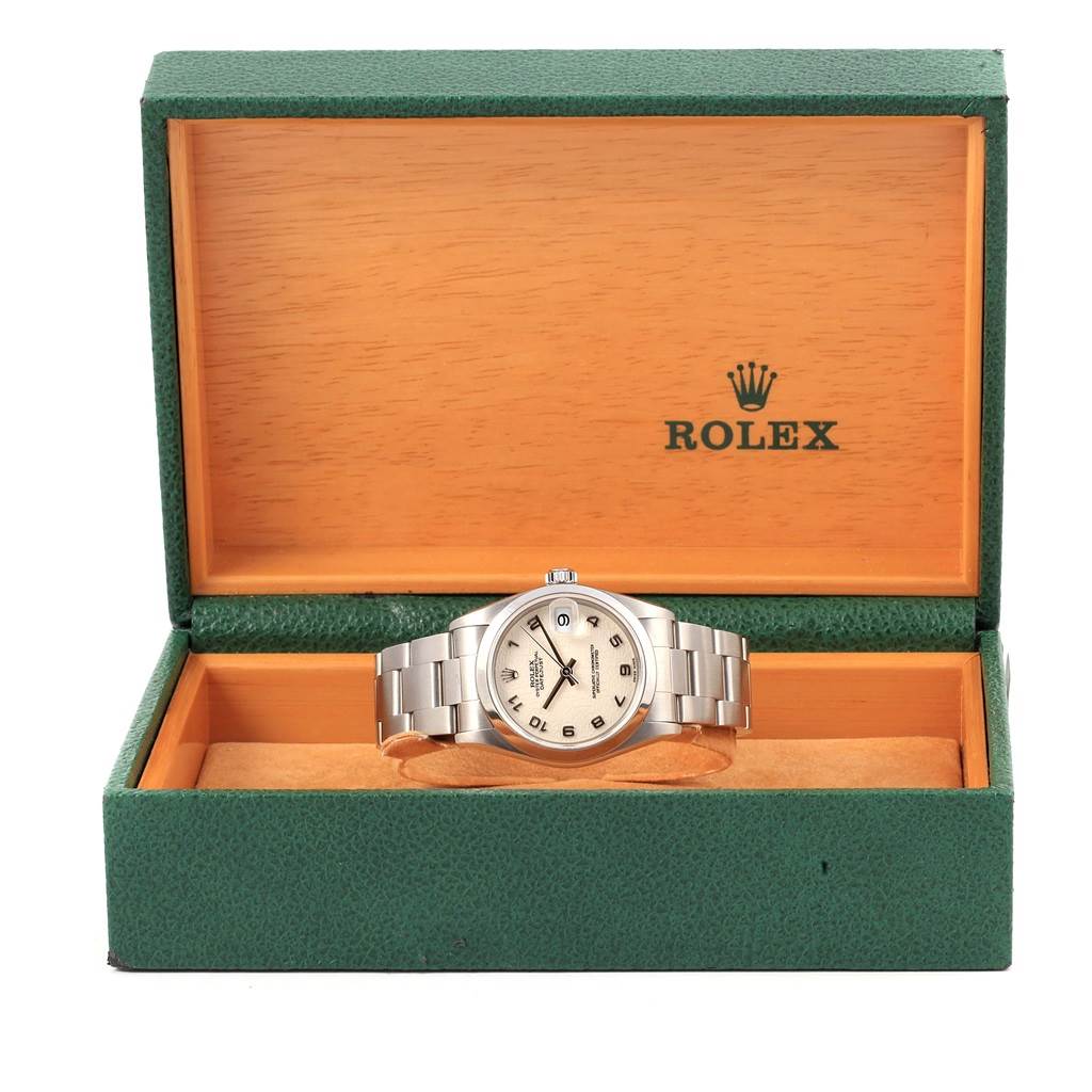 The Mid-Size Rolex watch is displayed front-facing in its green and wooden Rolex box.