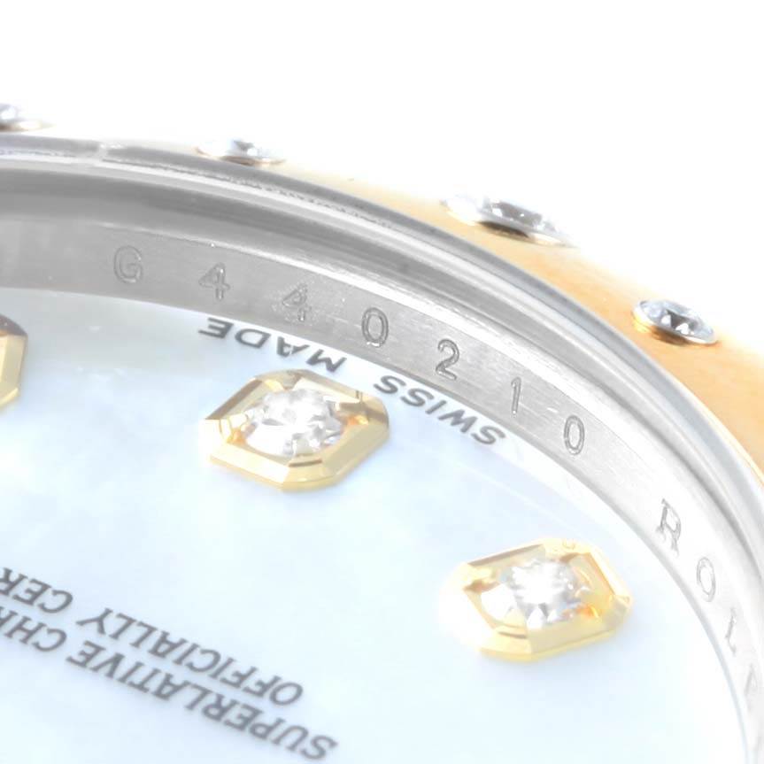 This image shows a close-up of the Rolex Mid-Size 178343 Women's Steel and Gold (two tone) Mother of Pearl Dial 178343 Women's Steel and Gold (two tone) Mother of Pearl Dial watch with visible serial numbers, part of the bezel, and diamond markers on the dial.