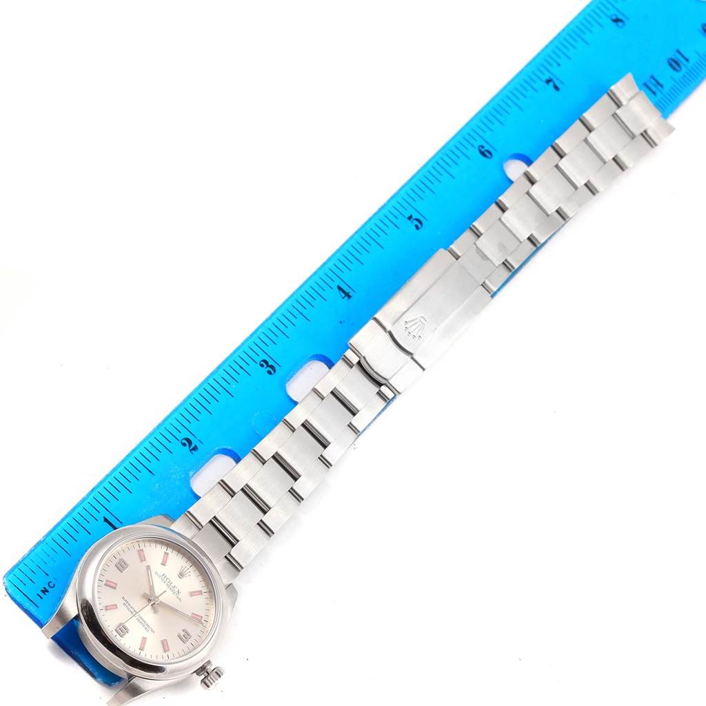 The image shows a top-down view of a Mid-Size Rolex watch, including the face, links, and clasp, next to a ruler.