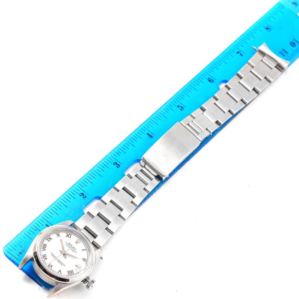 The image shows a Rolex Mid-Size 68240 Women's Stainless Steel White Dial 68240 Women's Stainless Steel White Dial watch laid flat next to a blue ruler for scale, displaying its face and full metal bracelet.