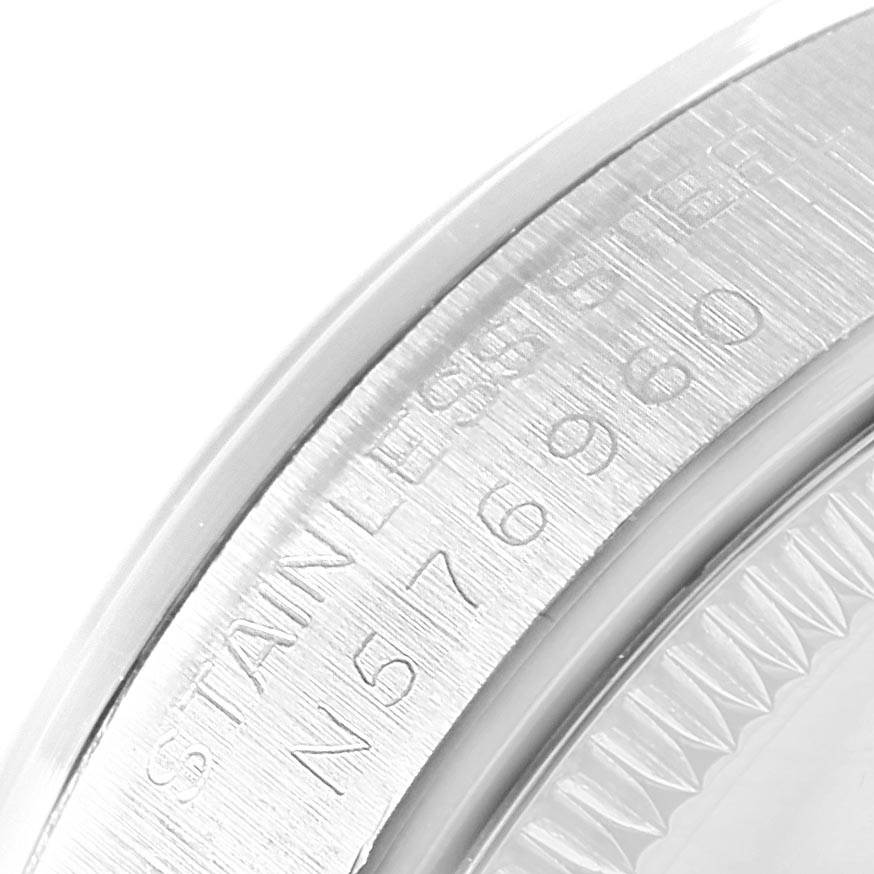 This image shows a close-up of the engraved case back and edge of the bezel of a Mid-Size Rolex watch.