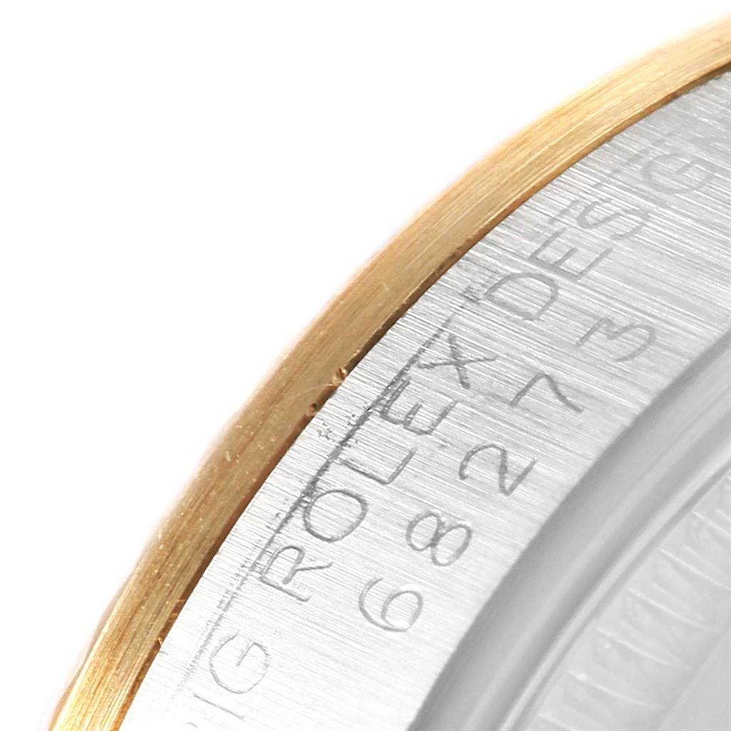 The image shows a close-up of the bezel and engraved edge of a Mid-Size Rolex watch.