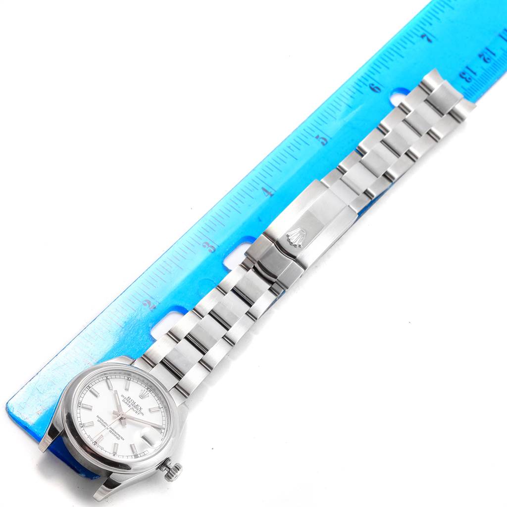 The image shows a top-down view of a Mid-Size Rolex watch, including its dial, bracelet, and clasp, placed next to a ruler.