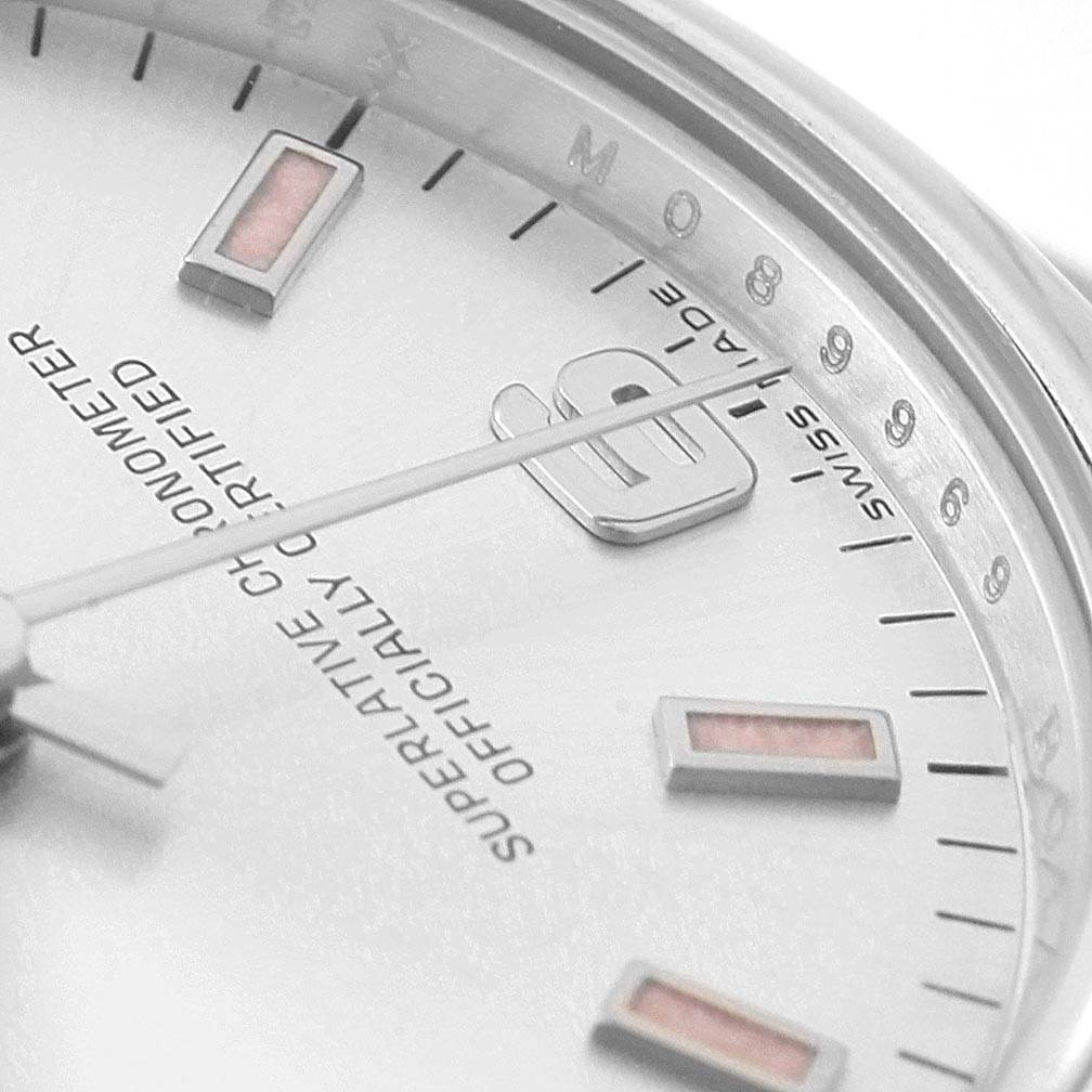 This image shows a close-up of the dial and bezel of a Mid-Size Rolex watch, highlighting the markings and part of the hour markers.