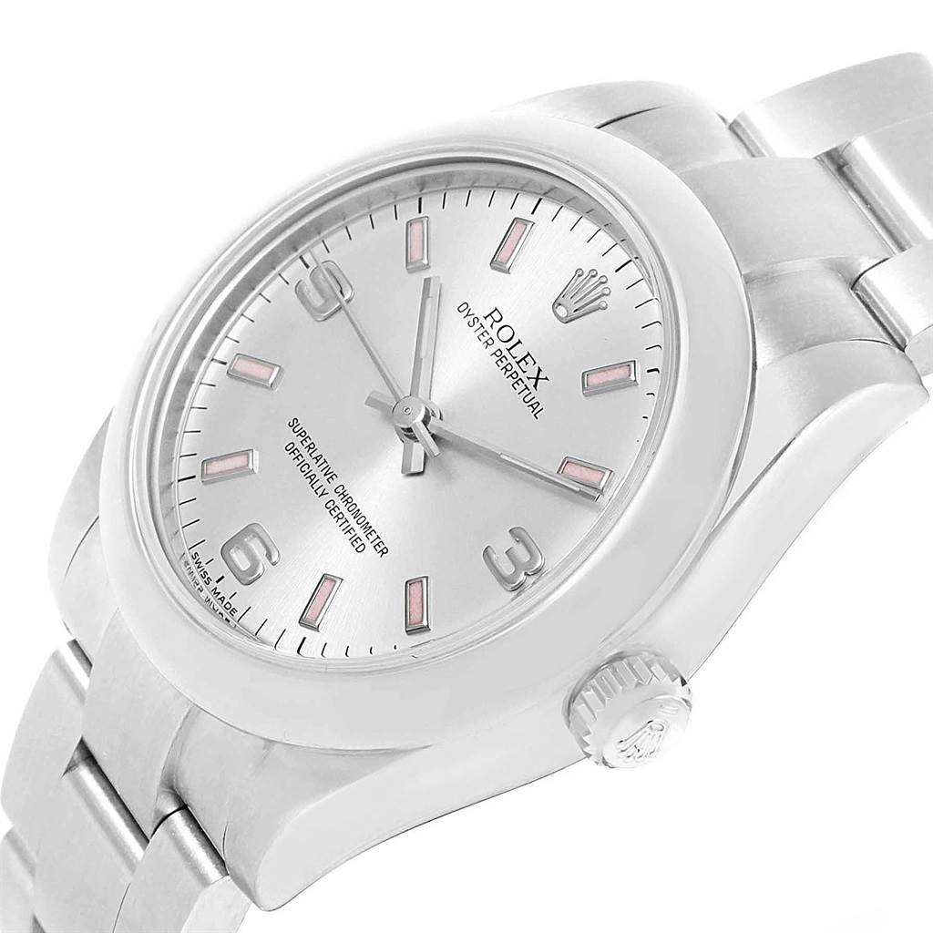The Rolex Oyster Perpetual Mid-Size watch is shown from a slightly tilted angle, displaying the dial, bezel, crown, and part of the bracelet.