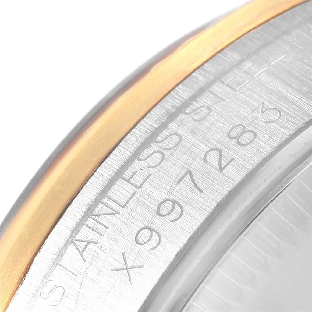 Close-up angle of the bezel and engraved serial number on a mid-size Rolex watch.