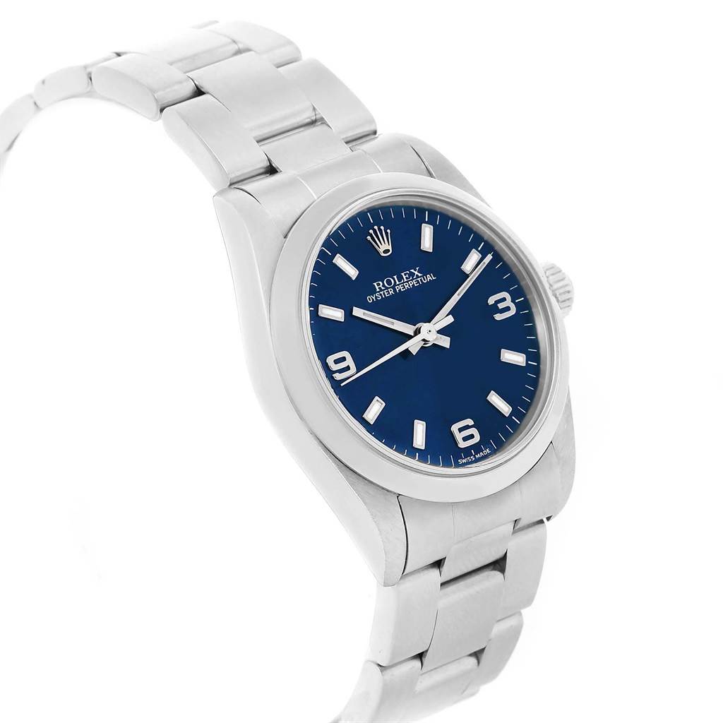 The image shows a side angle of a Rolex Oyster Perpetual Mid-Size model with a blue dial and a stainless steel bracelet.