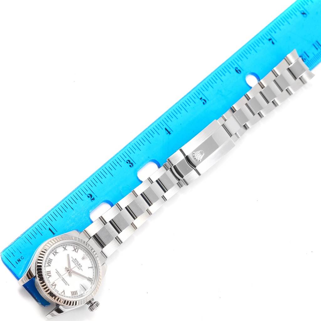 The image shows a Rolex Mid-Size 178274 Men's Stainless Steel White Dial 178274 Men's Stainless Steel White Dial model watch laid flat, alongside a ruler, displaying the dial, bezel, bracelet, and clasp.