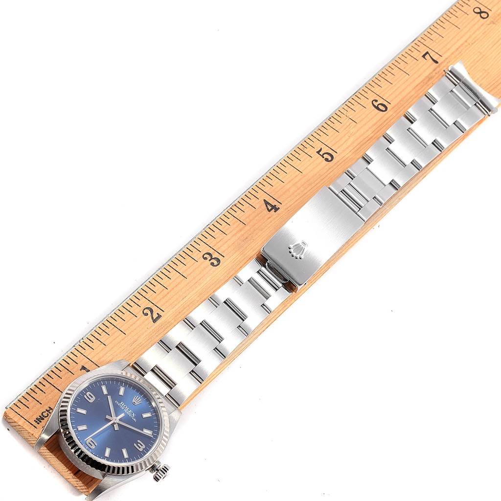 The Rolex Mid-Size 77014 Women's Stainless Steel Blue Dial 77014 Women's Stainless Steel Blue Dial model watch is shown laid flat from an overhead angle, with entire bracelet and clasp visible next to a ruler.