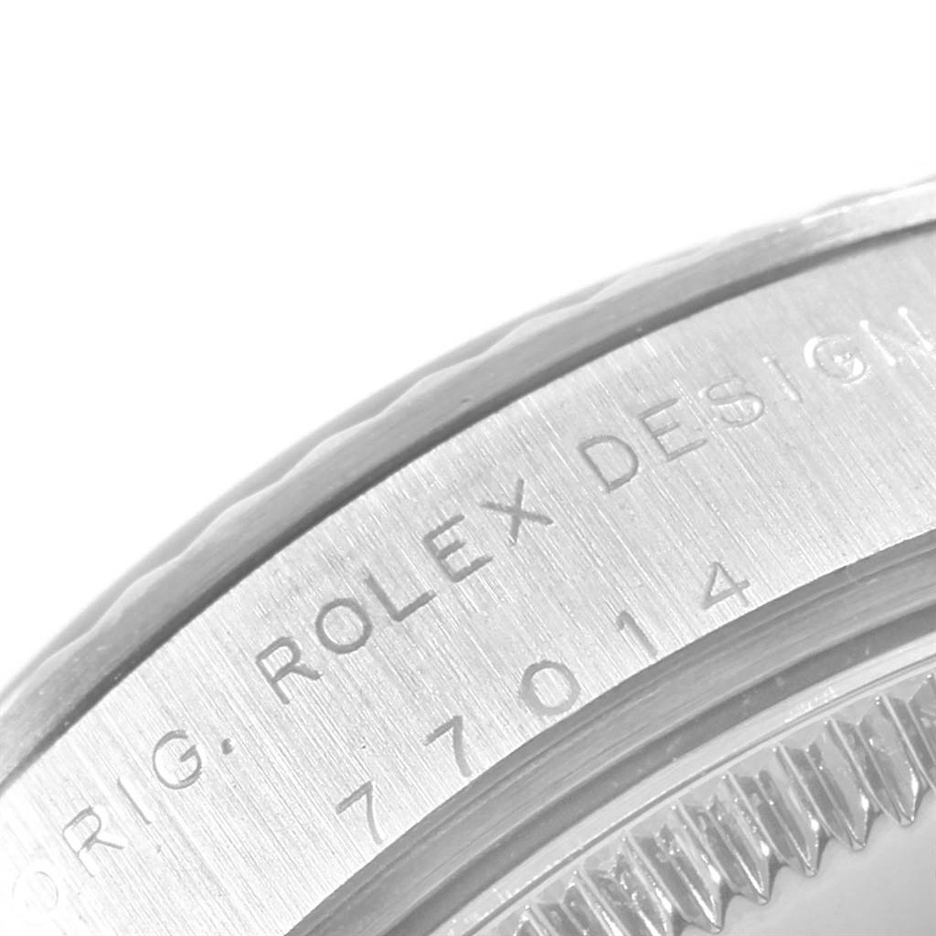 The image shows a close-up angle of the case back of a Rolex Mid-Size 77014 Women's Stainless Steel Blue Dial 77014 Women's Stainless Steel Blue Dial model, including part of the bezel and engraved design number.