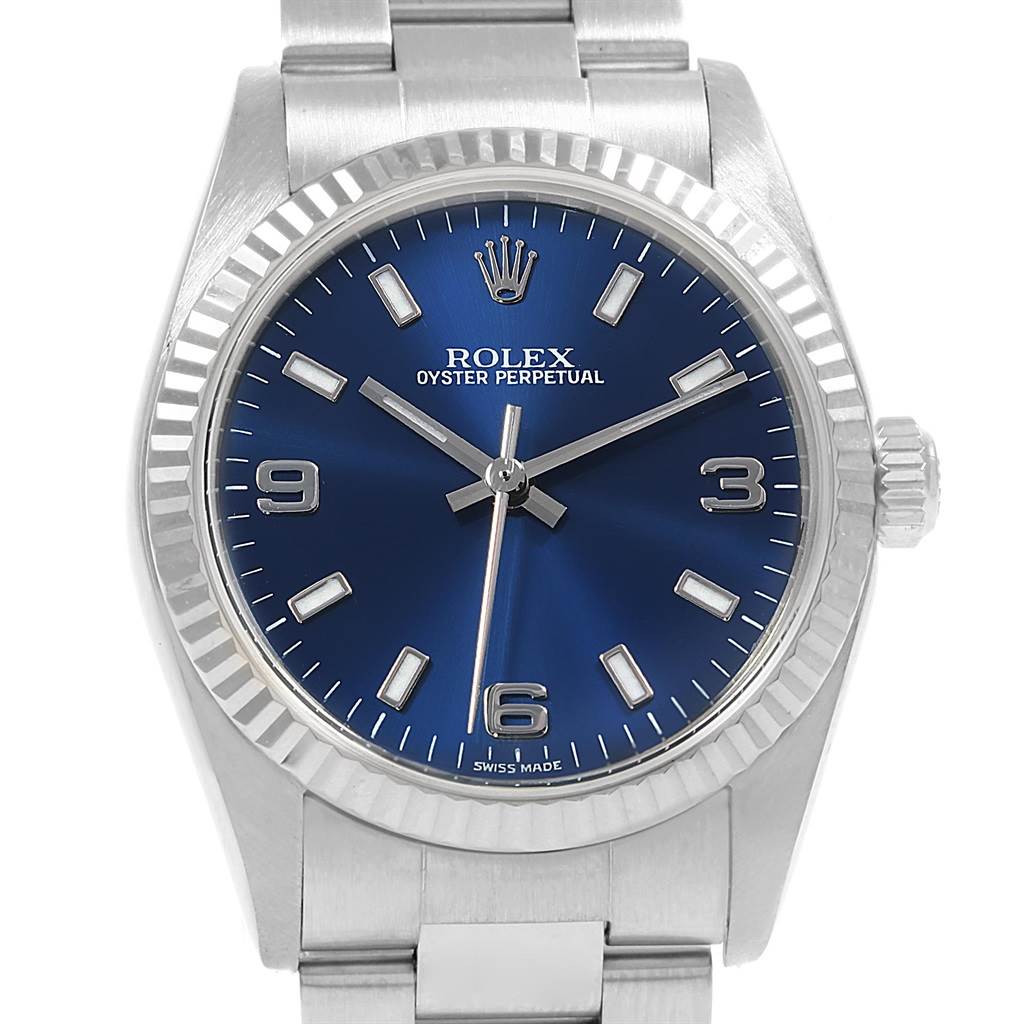 This is a frontal view of a Rolex Mid-Size 77014 Women's Stainless Steel Blue Dial 77014 Women's Stainless Steel Blue Dial Oyster Perpetual watch displaying the dial, case, bezel, and part of the bracelet.