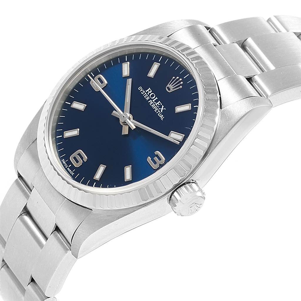 This image shows a side angle view of a Rolex Mid-Size 77014 Women's Stainless Steel Blue Dial 77014 Women's Stainless Steel Blue Dial Oyster Perpetual watch, highlighting its blue dial, bezel, and crown.