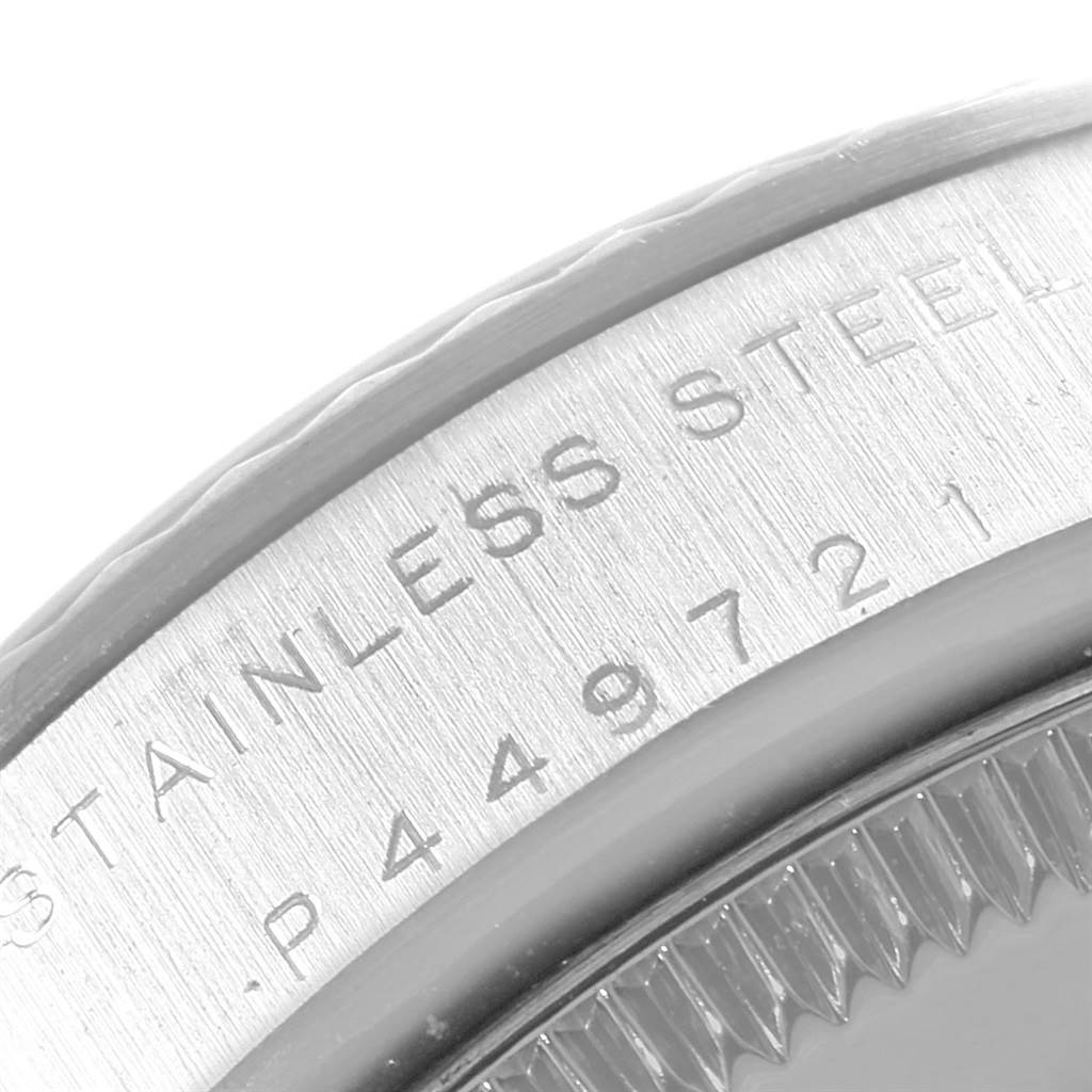 This close-up shows the engraved stainless steel bezel and part of the fluted edge on a Mid-Size Rolex watch.
