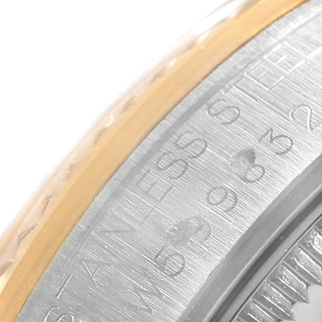 This image shows a close-up of the side of a Rolex Mid-Size 68273 Women's Steel and Gold (two tone) Beige Dial 68273 Women's Steel and Gold (two tone) Beige Dial watch, featuring part of the bezel and the engraved case back.