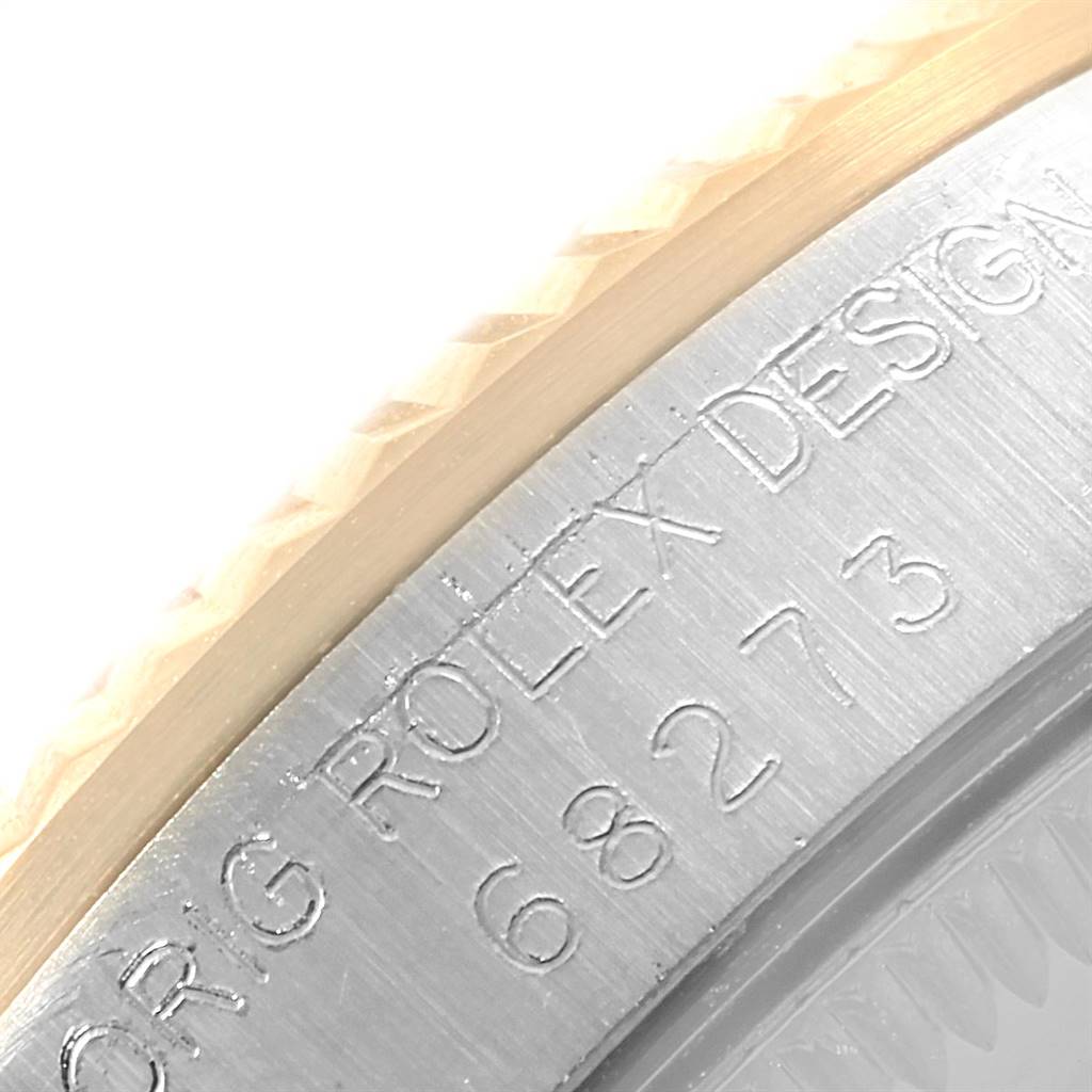 This close-up image of the Rolex Mid-Size 68273 Women's Steel and Gold (two tone) Champagne Dial 68273 Women's Steel and Gold (two tone) Champagne Dial model focuses on the engraved serial number and design details on the watch case.